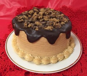 A chocolate cake with peanut butter frosting and nuts.
