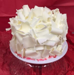 A white cake with red sprinkles on top of it.